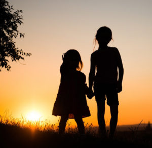 Girls silhouetted against a sunset
